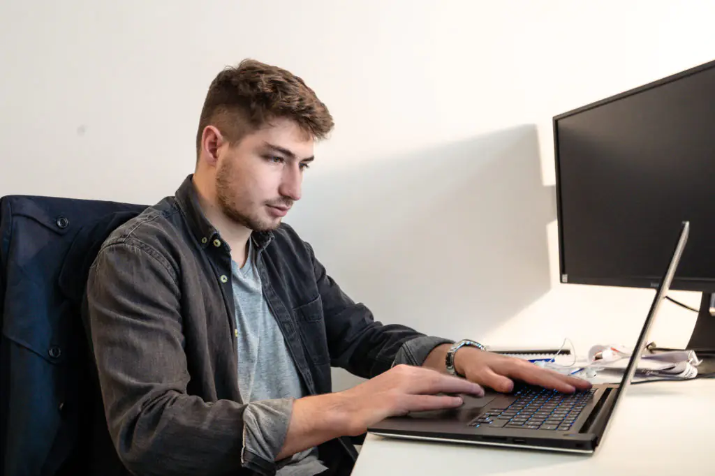 Homme travaillant sur un ordinateur portable au bureau. Illustration pour le blog sur les emplois.