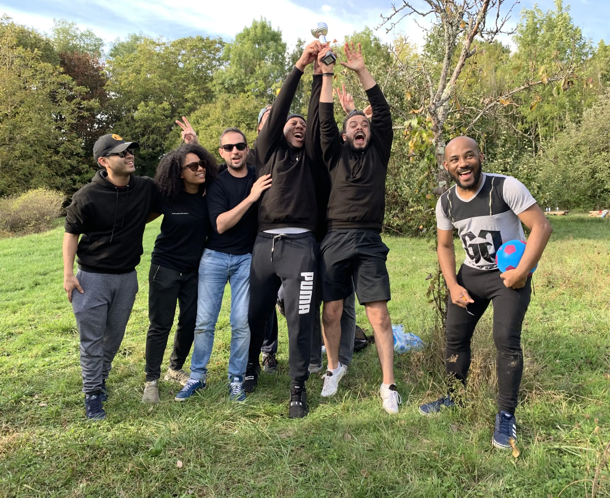 Équipe célébrant une victoire avec un trophée. Collègues joyeux après avoir trouvé des jobs.