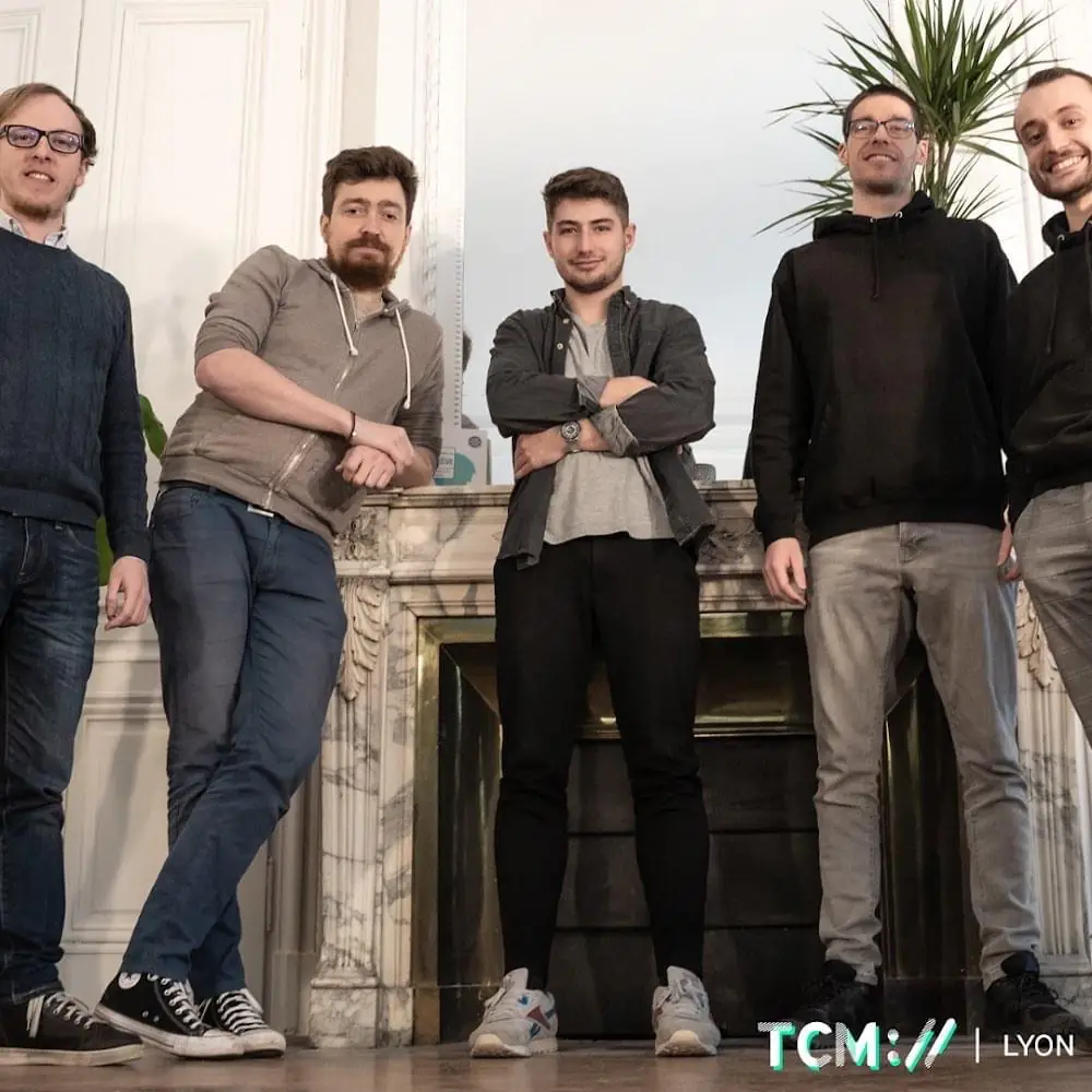 Collaborateurs de l'agence de développement à Lyon posant devant une cheminée.