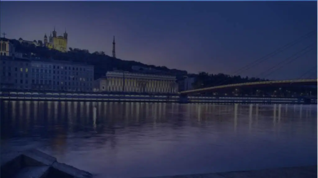 Vue nocturne de Lyon avec la basilique de Fourvière et le pont illuminés sur le Rhône.